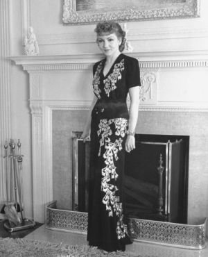 Claudette Colbert poses in front of the fireplace in her home in Holmby Hills 1939